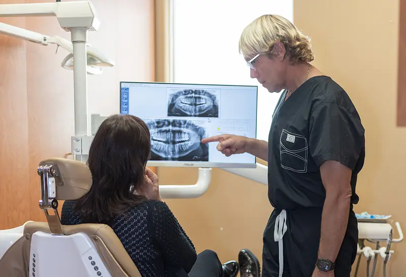 Dentist explaining dental X-rays to a patient during a consultation