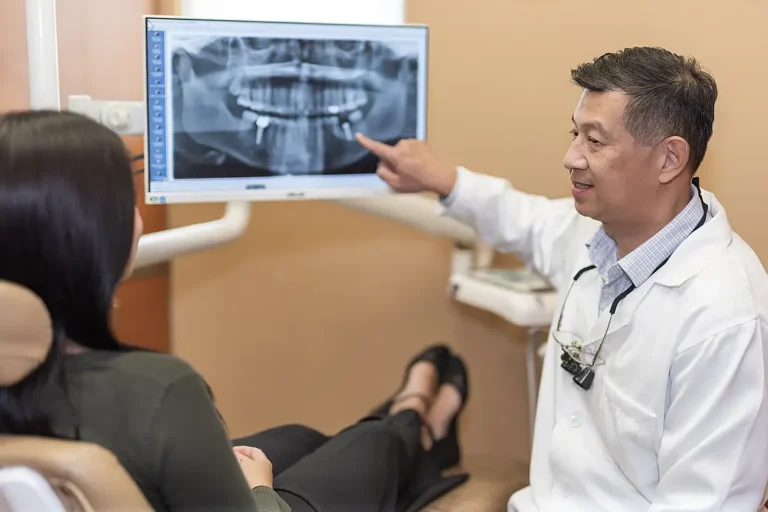 Dr. Tom Jou reviewing a panoramic X-ray with a patient